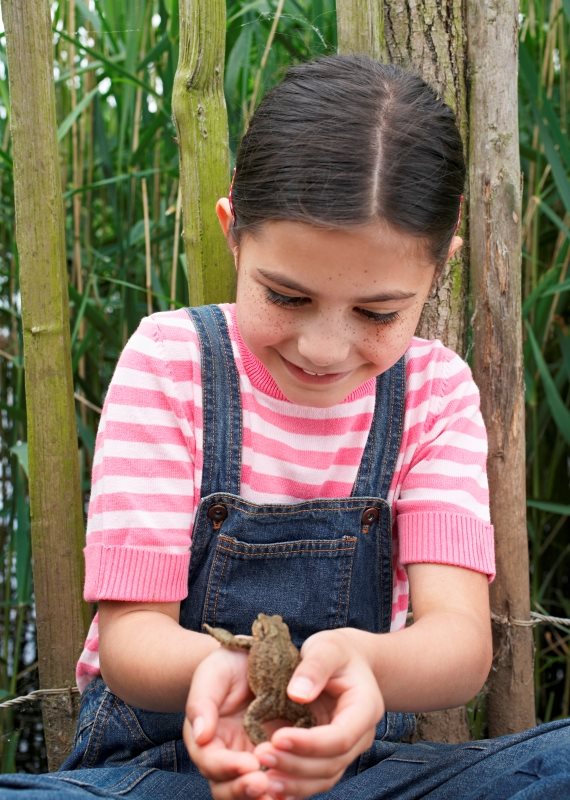 ילדה מחזיקה צפרדע